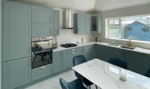 Hand-painted sage green cabinets with brass handles.