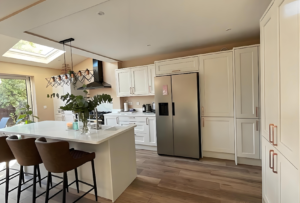 Kitchen island with breakfast seating in a Shaker fitted kitchen, finished with Calacatta-style quartz worktop in a bright open-plan space. 
