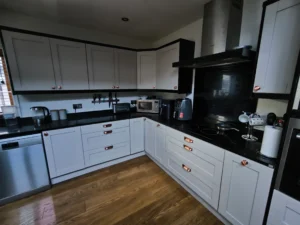 Contemporary shaker kitchen with white cabinets and black worktops