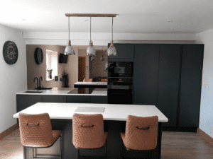 Handleless slab kitchen in Dublin with dark green cabinets, island and tall storage.