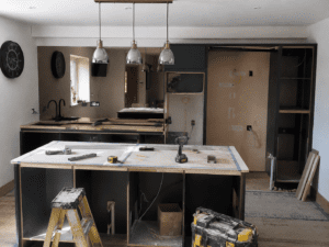 Handleless slab kitchen installation in Dublin with island, tall storage and fitted appliance units.