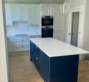 Marine blue shaker kitchen island in Dublin with white worktops and integrated ovens.