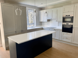 White and marine blue shaker kitchen in Dublin with central island and snow white worktops.