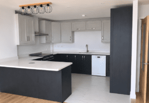Indigo and grey Shaker U-shaped kitchen in Lucan, Dublin with peninsula, white worktops, dishwasher and statement pendant lighting