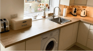 Oak effect worktop and sink area in a Dublin linen slab kitchen