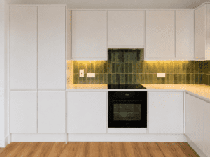 Cooking wall with integrated oven and green splashback
