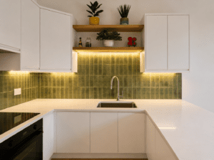 Sink and peninsula area with green tile splashback