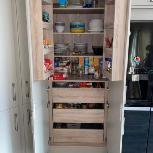 Open pantry storage in tall taupe kitchen cabinet in Dublin renovation project