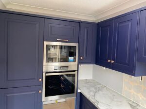Integrated oven and microwave housing in an indigo blue Shaker kitchen in Clontarf, Dublin