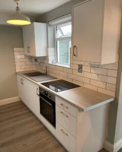 White Grey galley kitchen with window sink and integrated hob in Santry