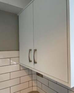 White Grey wall cabinets with silver handles in a Santry galley kitchen