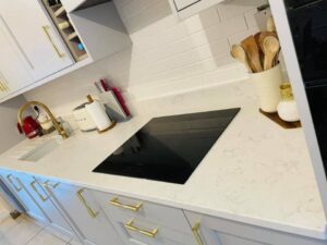 White quartz worktop and hob in a light grey Shaker kitchen in Blackrock, Dublin