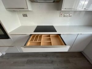 Wide cutlery drawer organiser in a white handleless kitchen in Malahide, Dublin