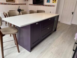 Crystal White Quartz island worktop with deep drawers and a glass-fronted wine cooler built into the cabinetry