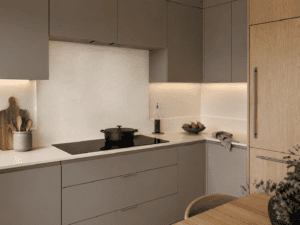 Full-height light stone-effect splashback behind an induction hob in a taupe handleless kitchen with oak cabinetry in an Irish home.