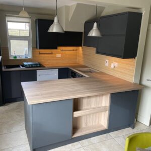 Graphite handleless U-shaped kitchen with an oak-effect breakfast bar and open shelving in a Drumcondra, Dublin home