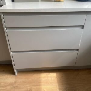 Wide storage drawers with recessed handle channels in a light grey handleless kitchen