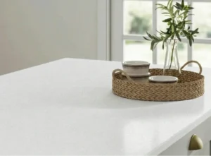 Close-up of a snow white laminate kitchen worktop styled with a woven tray and greenery in an Irish home