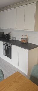 White Grey handleless kitchen cabinets with a dark worktop and integrated oven in Lucan, Dublin