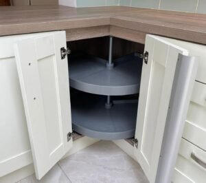 Two-tier rotating corner carousel storage inside a white shaker corner base unit