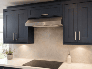 Extractor hood fitted between navy Shaker wall units above an induction hob in an Irish kitchen
