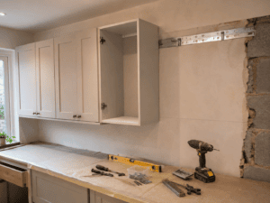Kitchen wall units being installed on a metal hanging rail fixed to an Irish hollow concrete block wall