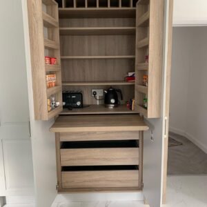 Open custom breakfast storage cabinet in a Castleknock kitchen, with a pull-out worktop and internal drawers