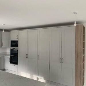 Tall unit run in a Castleknock kitchen with the hidden door closed, matching the neighbouring cabinetry