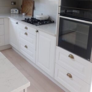 NEFF oven in a tall unit in a Clontarf kitchen, with drawers below and a three-drawer stack under the hob