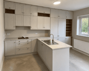 Portmarnock White Shaker kitchen viewed from the side, showing the peninsula and sink connection