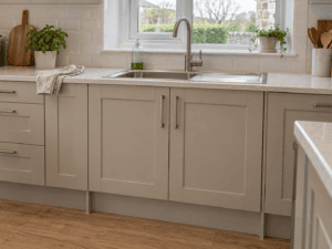 Taupe Shaker kitchen sink base cabinet beneath a stainless steel sink in an Irish kitchen.