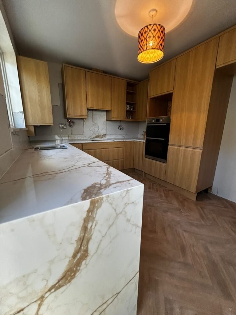 Quartz waterfall end with continuous veining Close view of a white quartz waterfall end with gold and grey veining running from the worktop down the side panel